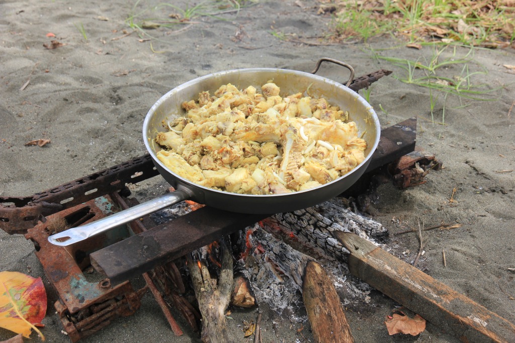 焚き火で食事の準備をする＝2019年9月、ガダルカナル島北岸部で筆者撮影