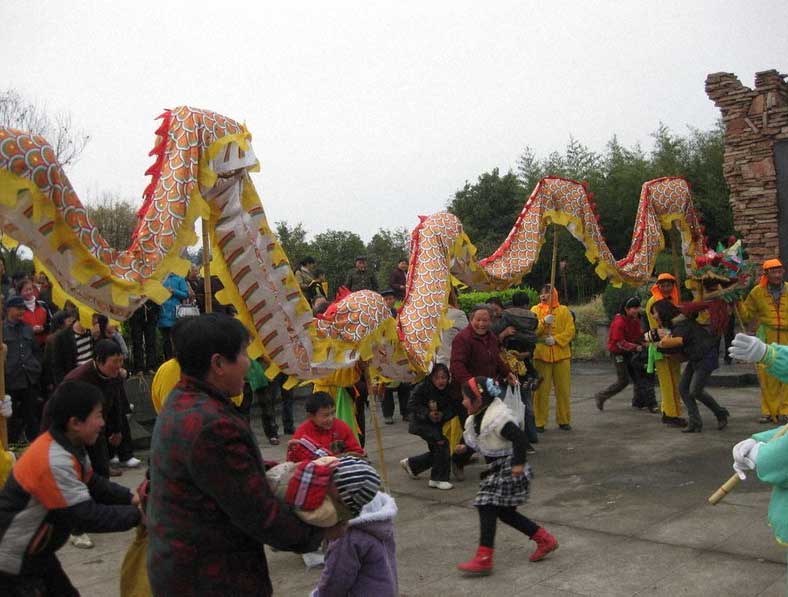 無病息災を祈って龍の下をくぐる女性と子どもたち＝中国安徽省和県で2009年、筆者撮影