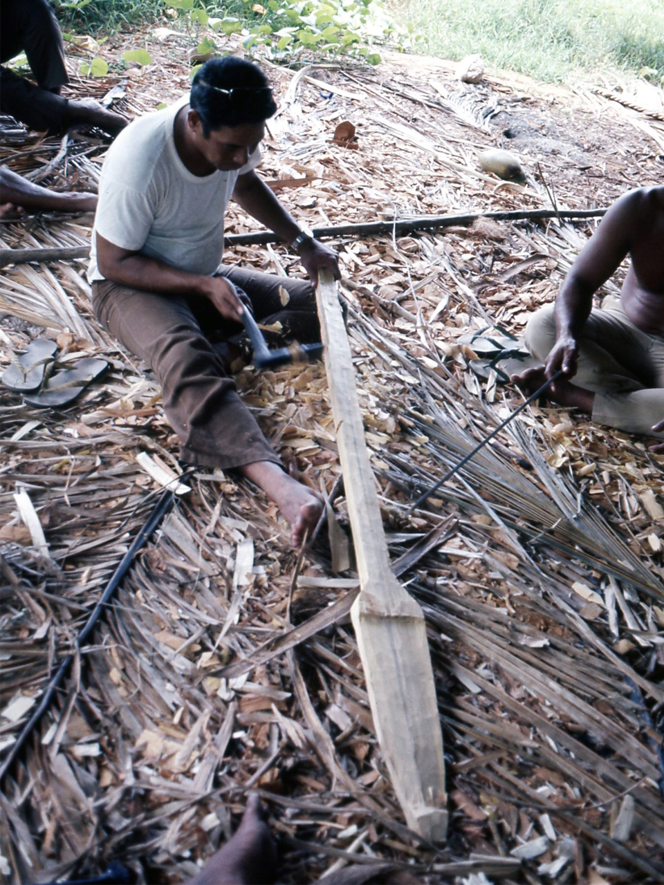 パンノキを手斧で削り櫂をつくる男性 （ミクロネシアチューク州ウルル島、1974年、撮影：須藤健一）